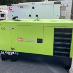a green pramac generator in a yard full of other generators